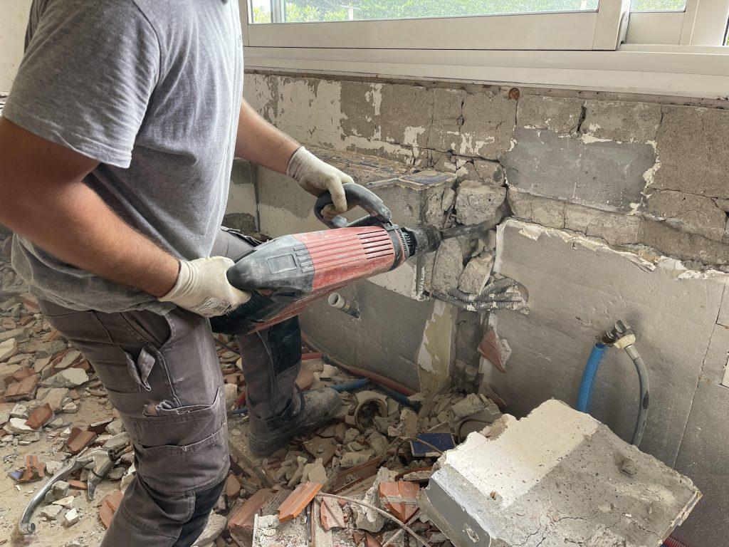 Ouvrier DBJ33 effectuant une démolition à Bordeaux à l’aide d’un marteau-piqueur.